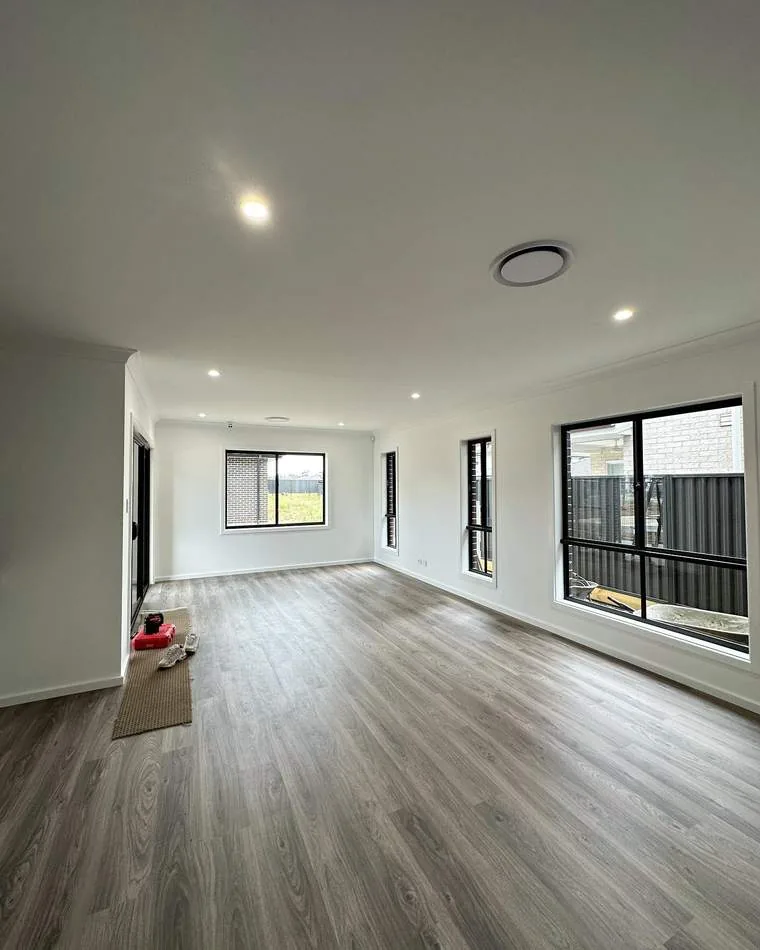 Open plan living room with recessed downlights and ceiling ventilation